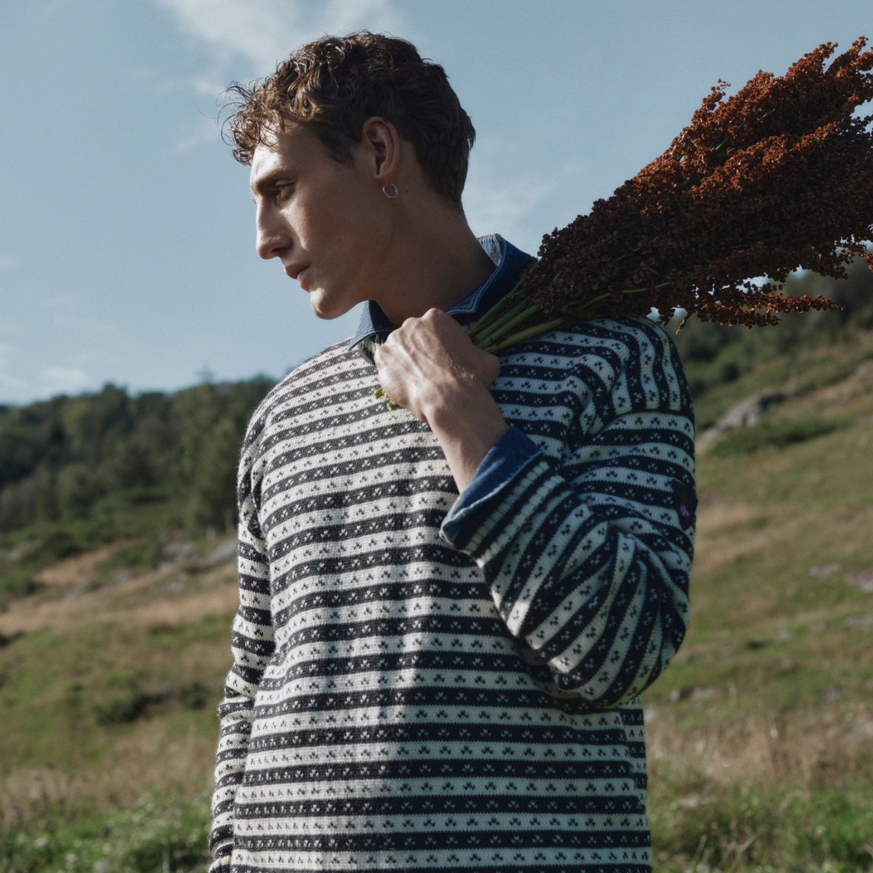 Male model wearing black and white knitted sweater outdoor in the field