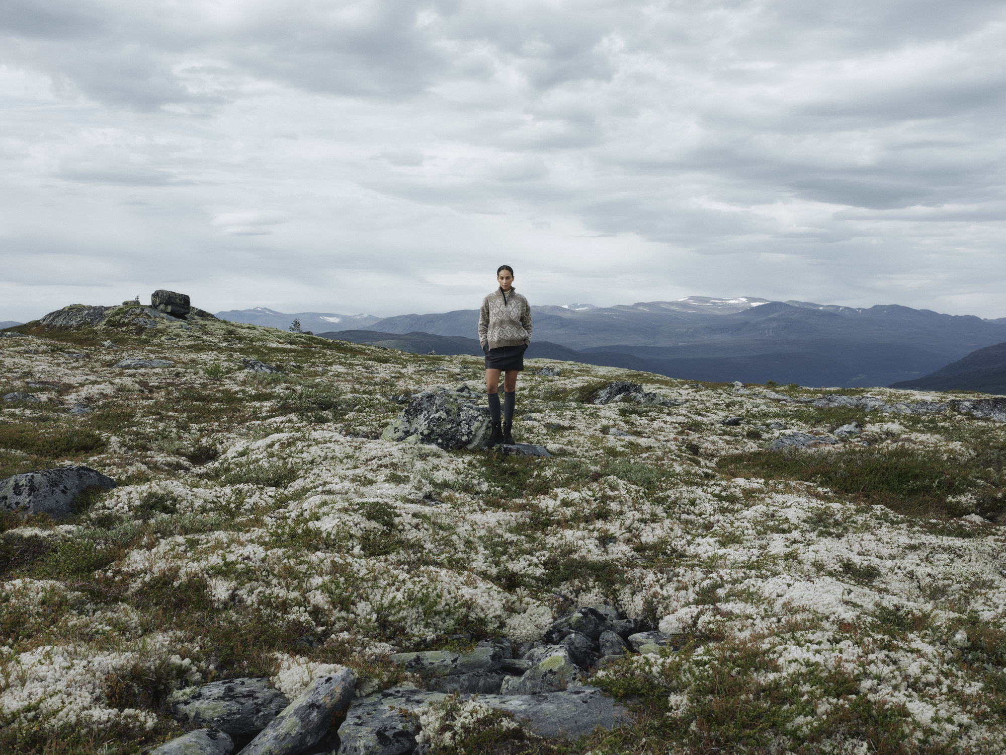 Female model wearing the new 2025 spring collection sweater Roset from Dale of Norway. Norwegian nature in the background
