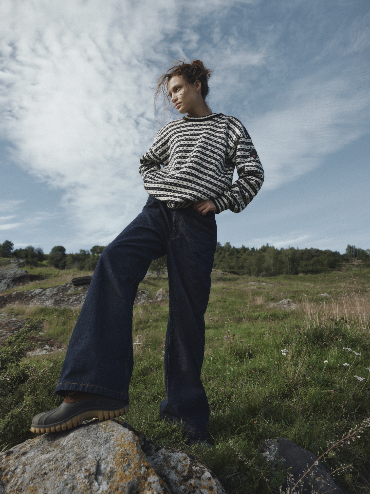 Female model wearing Skipsleia black and white wool sweater in outdoor spring surroundings