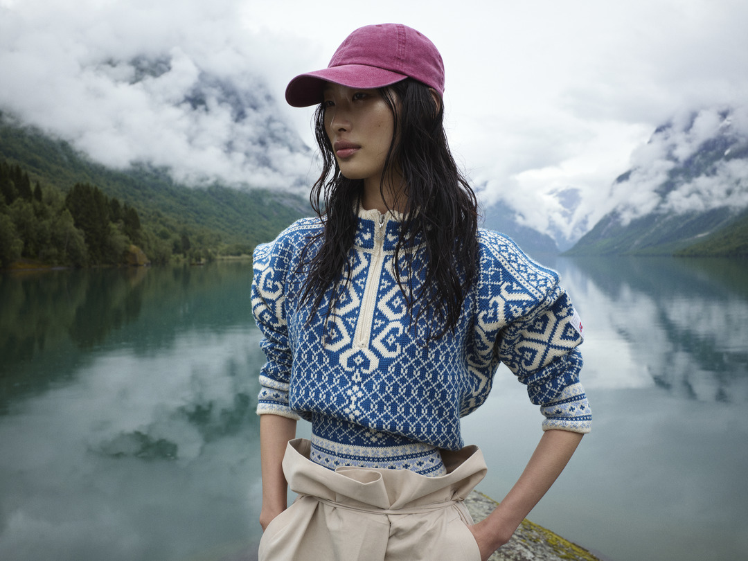 Woman standing in front of Norwegian fjords backdrop in Leknes women's sweater.